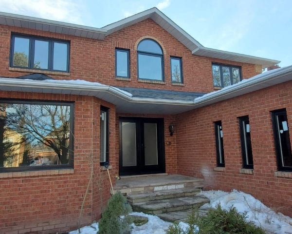 Image depicts a home with new vinyl windows and an entry door from our windows and doors Oakville project.